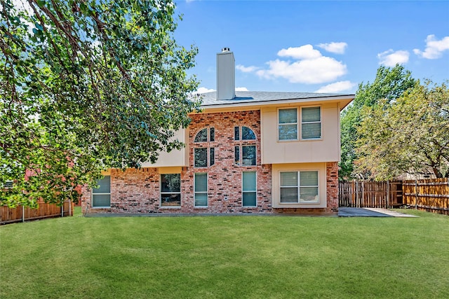 rear view of property with a lawn