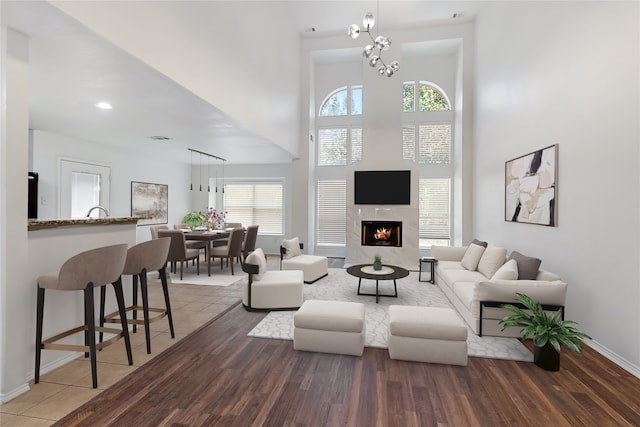 living room with dark hardwood / wood-style flooring, a fireplace, and a notable chandelier