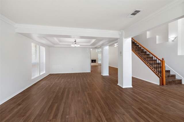 unfurnished living room featuring dark wood-type flooring, an inviting chandelier, a tray ceiling, and crown molding