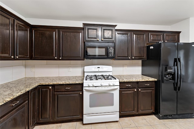 kitchen featuring light tile patterned floors, light stone counters, black appliances, and dark brown cabinets