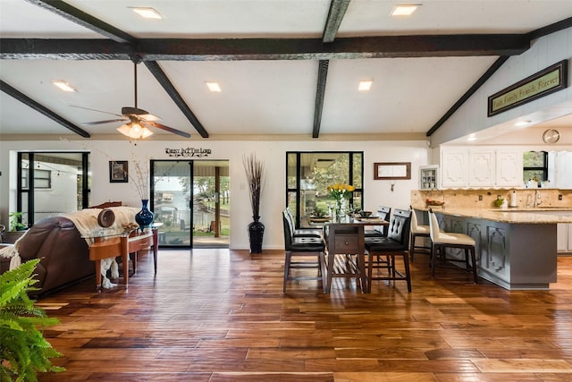 dining room featuring vaulted ceiling with beams, dark hardwood / wood-style floors, and ceiling fan