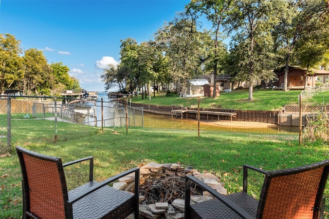 view of yard featuring a fire pit, a water view, and a storage unit