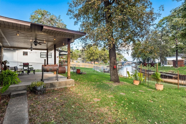 view of yard featuring ceiling fan and a water view