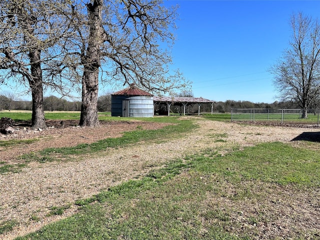 view of yard featuring a rural view and an outdoor structure