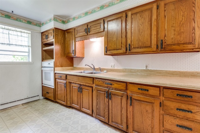 kitchen with sink, oven, and a baseboard heating unit