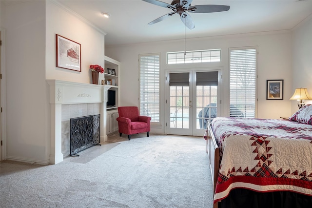 bedroom with crown molding, access to outside, light colored carpet, and a fireplace