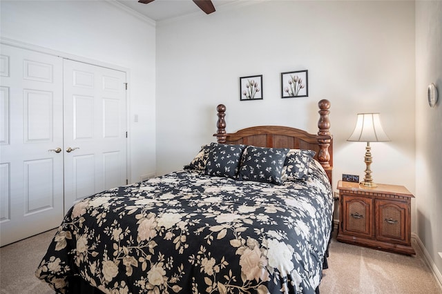 carpeted bedroom featuring ornamental molding, a closet, and ceiling fan