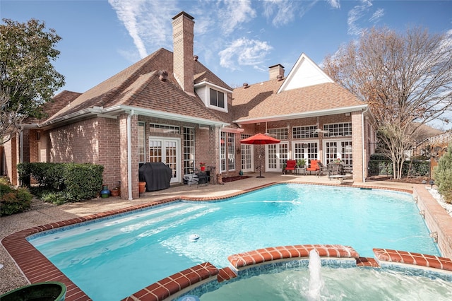 view of swimming pool featuring french doors, pool water feature, a grill, and a patio