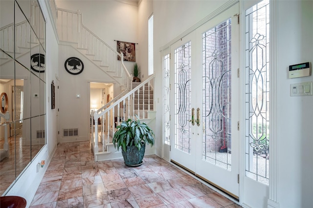 entryway with a towering ceiling and french doors