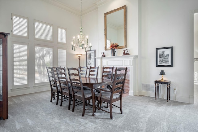 dining room with a high ceiling, ornamental molding, light carpet, and an inviting chandelier