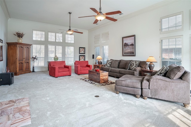 living room with crown molding, a towering ceiling, ceiling fan, and light carpet