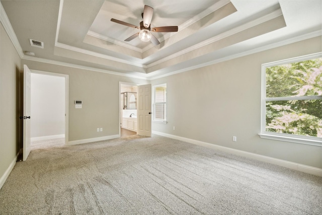 unfurnished bedroom featuring ceiling fan, multiple windows, ornamental molding, and a raised ceiling