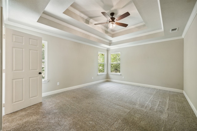 carpeted empty room with ceiling fan, a tray ceiling, and ornamental molding