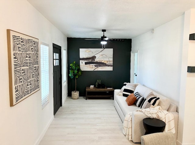 living room with light hardwood / wood-style flooring and ceiling fan