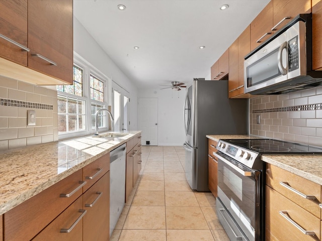 kitchen with light tile patterned floors, tasteful backsplash, appliances with stainless steel finishes, ceiling fan, and sink