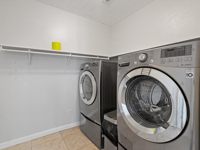 laundry area featuring washer and clothes dryer and light tile patterned flooring