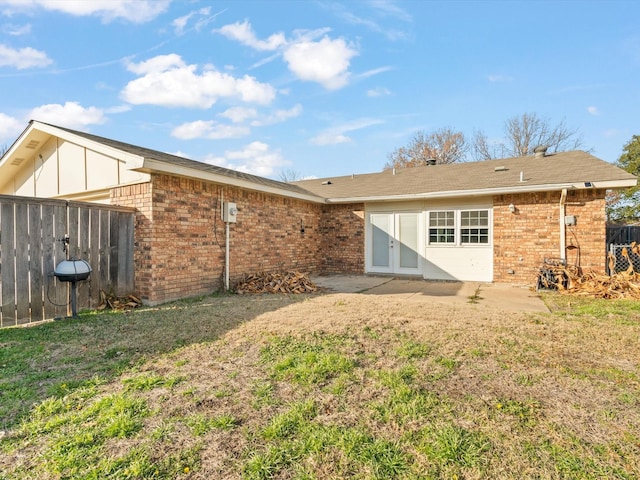 rear view of house with a lawn and a patio