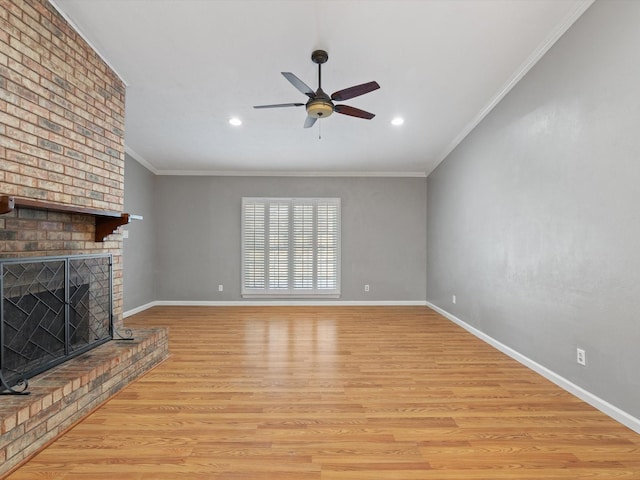 unfurnished living room with ornamental molding, ceiling fan, light wood-type flooring, and a fireplace