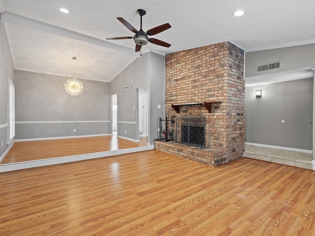 unfurnished living room featuring light hardwood / wood-style flooring, high vaulted ceiling, ceiling fan with notable chandelier, a fireplace, and ornamental molding