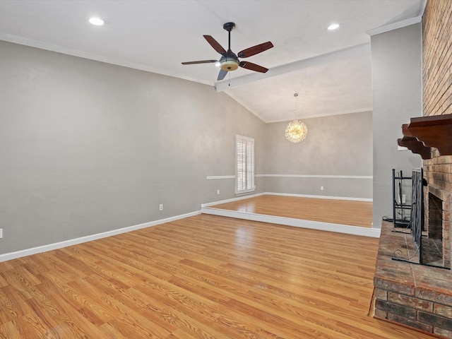 unfurnished living room with light hardwood / wood-style floors, lofted ceiling, crown molding, ceiling fan with notable chandelier, and a fireplace