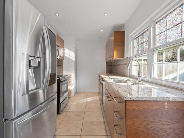 kitchen featuring electric range oven, sink, light tile patterned floors, backsplash, and stainless steel fridge with ice dispenser