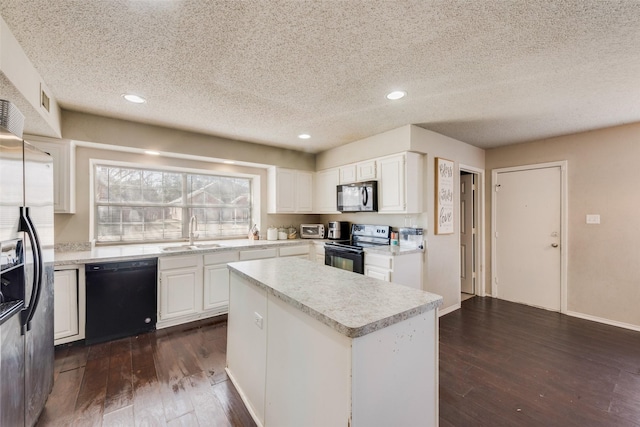 kitchen with a textured ceiling, black appliances, a kitchen island, white cabinetry, and sink