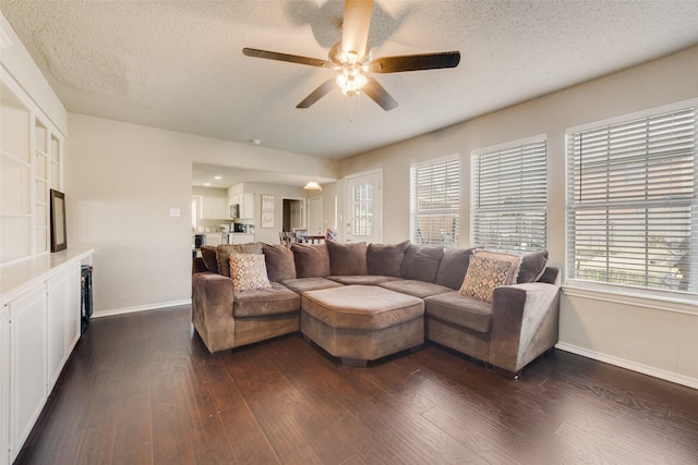 living room featuring dark hardwood / wood-style flooring, a textured ceiling, and ceiling fan