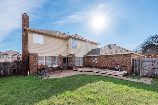 rear view of house featuring a patio area, a deck, and a lawn