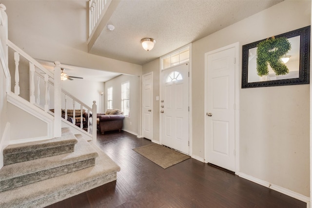 foyer featuring a textured ceiling, ceiling fan, and dark hardwood / wood-style floors