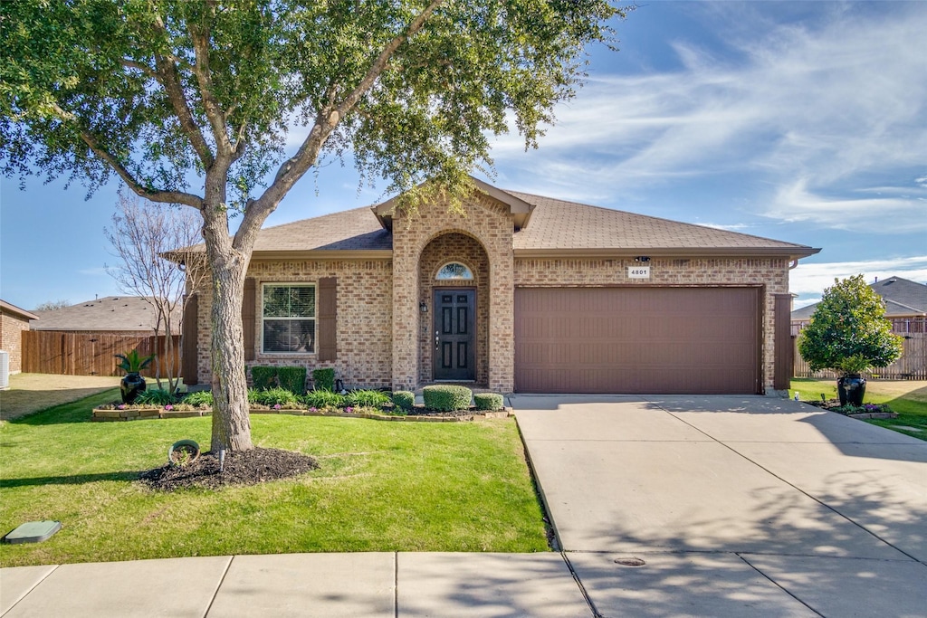 single story home featuring a garage and a front lawn