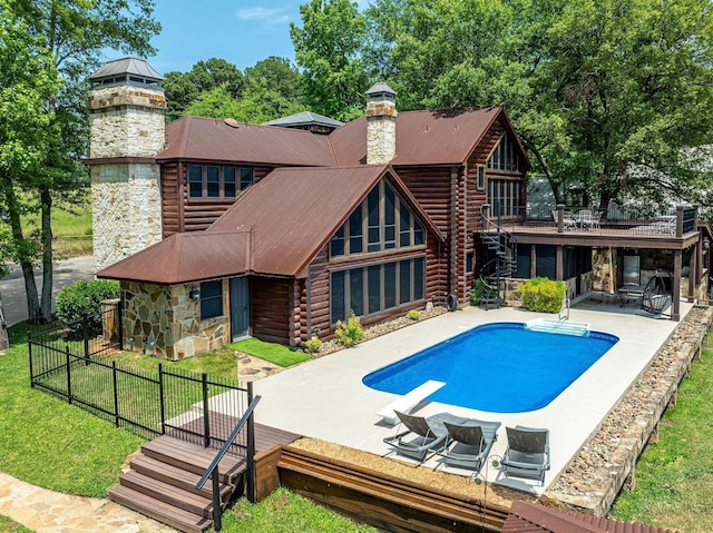 view of swimming pool featuring a diving board, a patio area, a wooden deck, and a yard