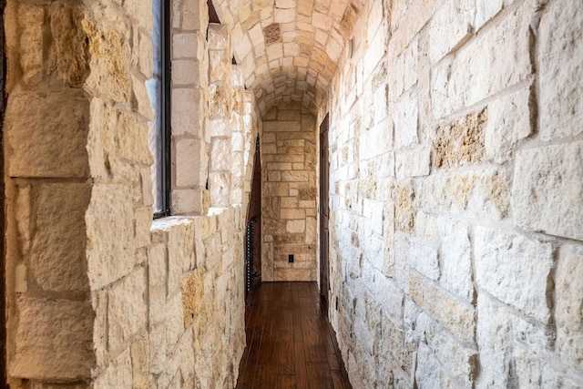 hallway with brick ceiling and dark hardwood / wood-style floors