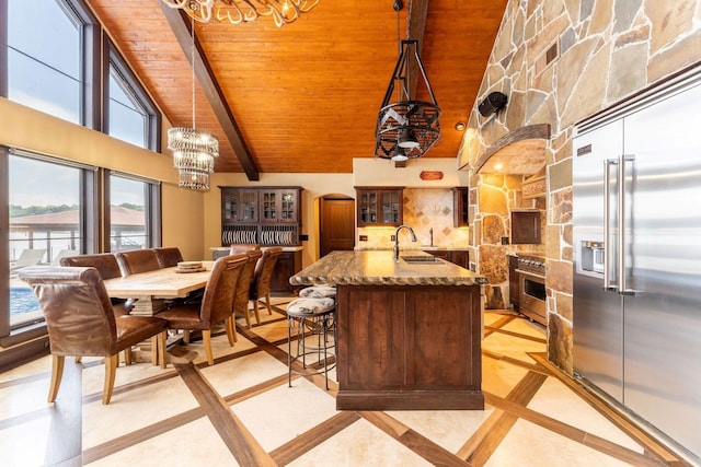 kitchen with wood ceiling, hanging light fixtures, stainless steel built in refrigerator, beam ceiling, and sink