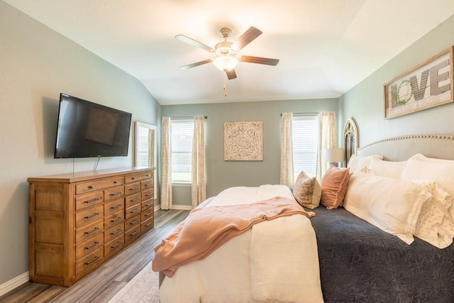 bedroom featuring ceiling fan, light hardwood / wood-style flooring, and vaulted ceiling