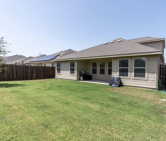 back of house featuring a lawn and a patio