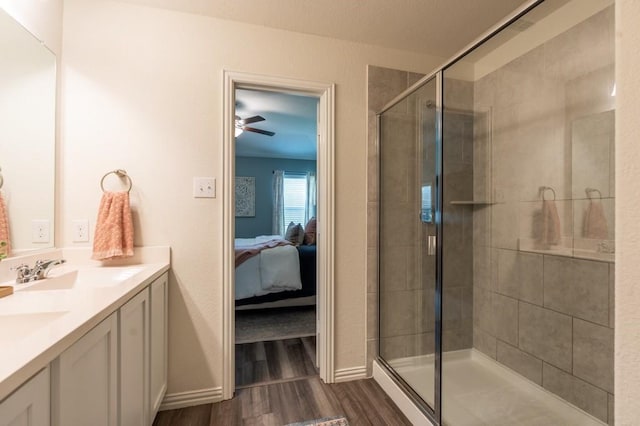 bathroom with walk in shower, vanity, ceiling fan, and hardwood / wood-style floors