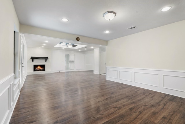 unfurnished living room with a brick fireplace, ceiling fan, and dark hardwood / wood-style flooring