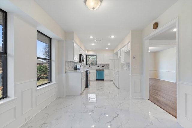 kitchen featuring white cabinets, backsplash, and appliances with stainless steel finishes