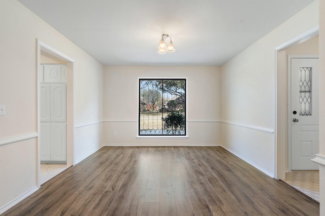 unfurnished dining area featuring an inviting chandelier and hardwood / wood-style flooring