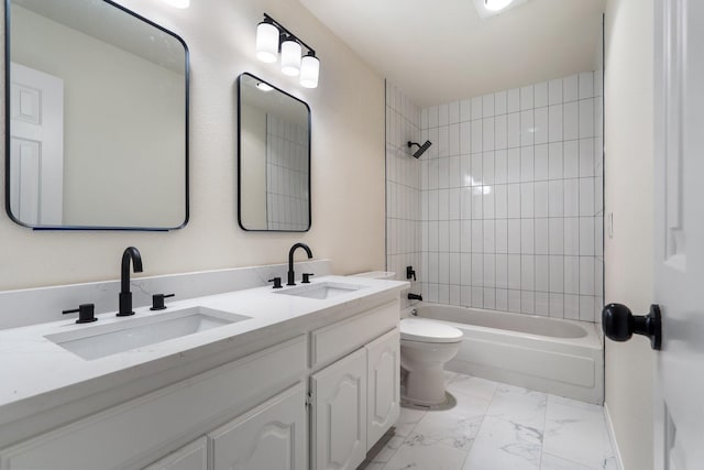 full bathroom with vanity, tiled shower / bath combo, and toilet