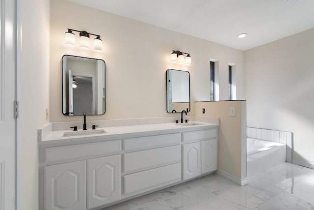 bathroom featuring vanity, a tub to relax in, and ceiling fan