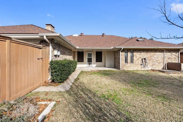 back of property featuring a patio and a yard