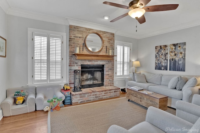 living room featuring a fireplace, ceiling fan, light hardwood / wood-style floors, and crown molding