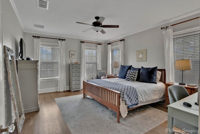 bedroom featuring ceiling fan, hardwood / wood-style flooring, and crown molding