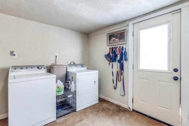 laundry room with washing machine and clothes dryer and a textured ceiling