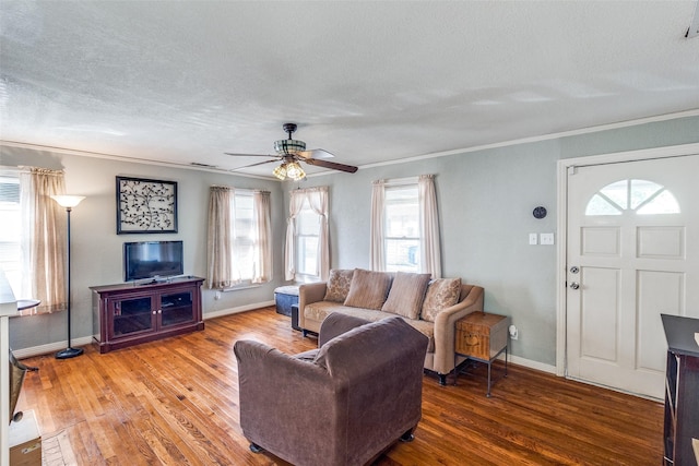 living room featuring hardwood / wood-style floors, ornamental molding, a textured ceiling, and ceiling fan