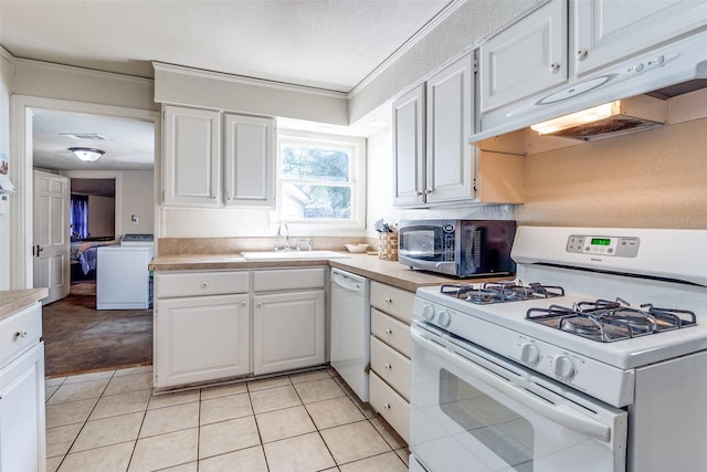 kitchen featuring washer / clothes dryer, white cabinetry, sink, and white appliances