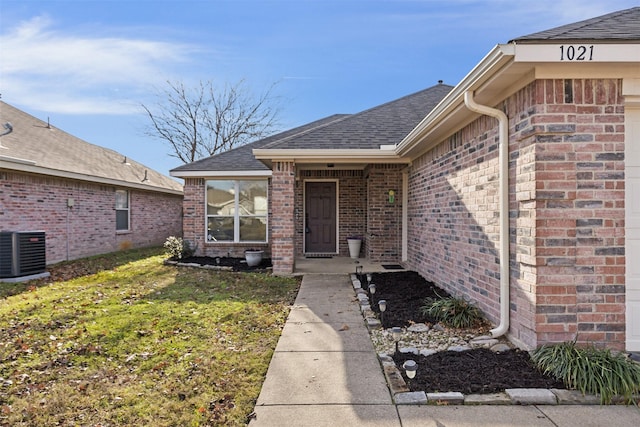 doorway to property featuring a lawn and cooling unit