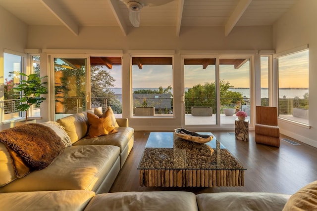 sunroom featuring beam ceiling, ceiling fan, and a water view