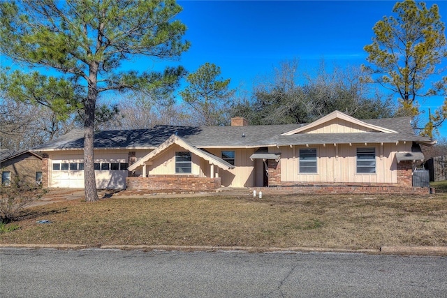 view of front of property with a front yard and a garage